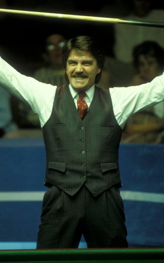 Cliff Thorburn in a pinstripe waistcoat, arms raised in celebration